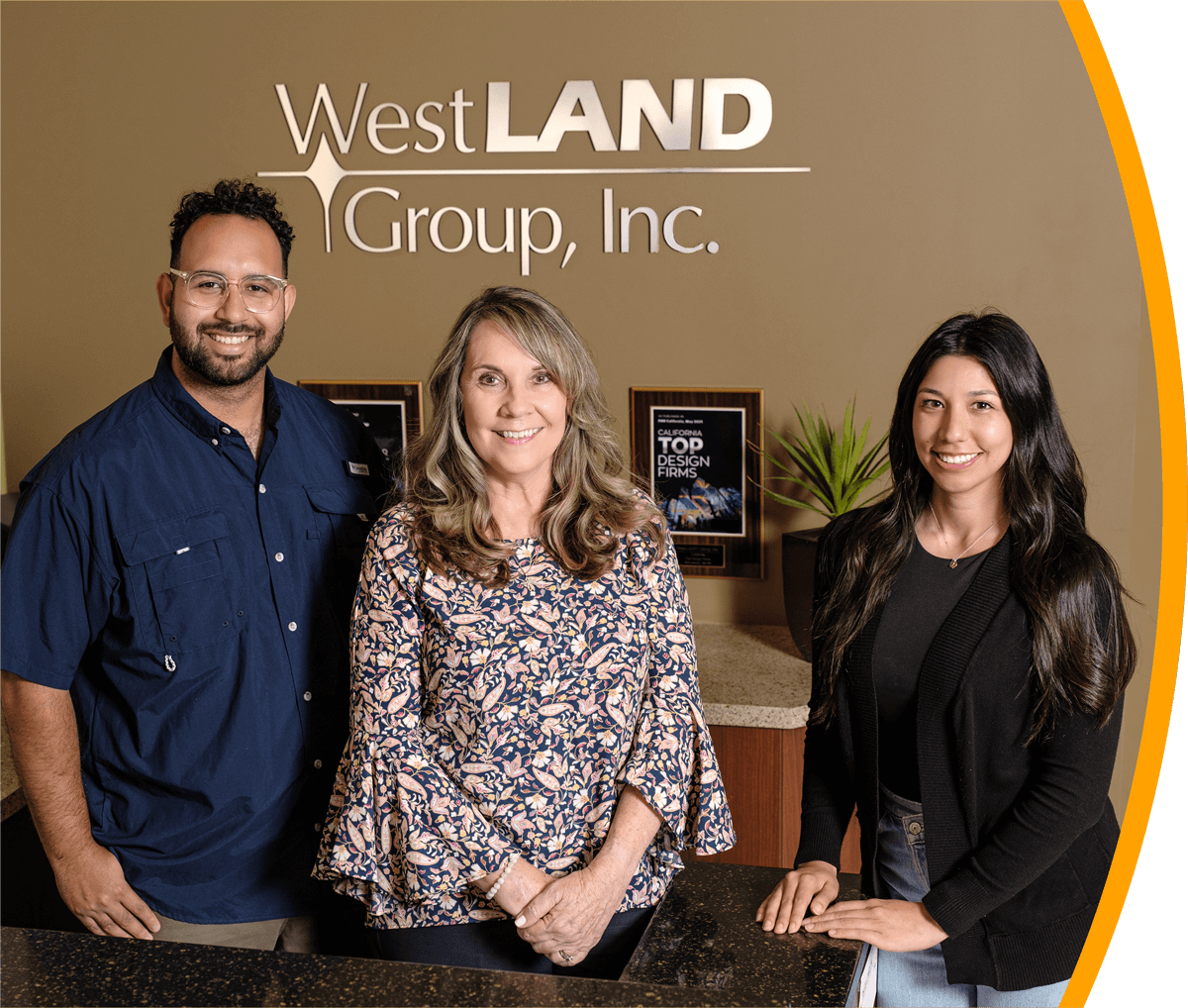 WestLAND's Group Who We Are Image - Shows WestLAND Group's employees standing over the WestLAND Group Signage and in front of Top Design Firm Award.